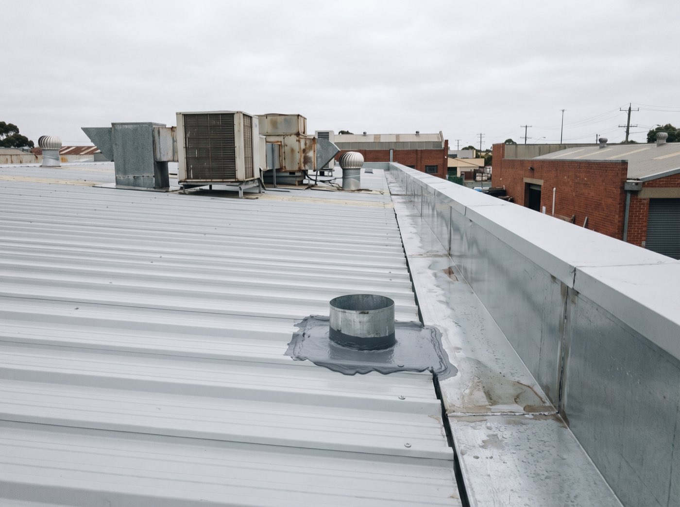 A finished commercial metal roof and box gutter on a Melbourne industrial unit